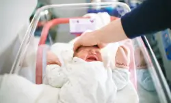 newborn baby crying in hospital crib